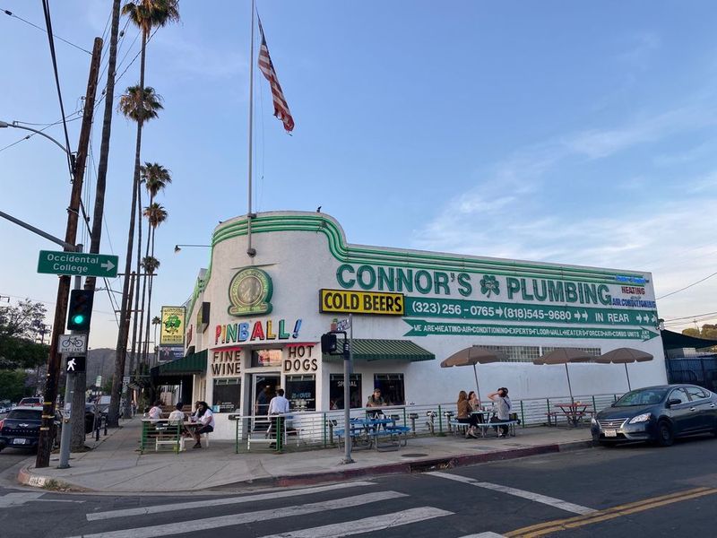 The white and green Connors Plumbing building in daylight
