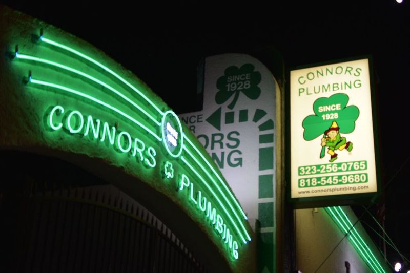 The green Connors Plumbing neon sign glowing on our wall